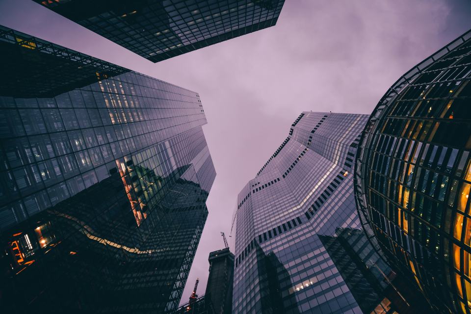Glass towers viewed upward, signaling cross-border commercial markets.